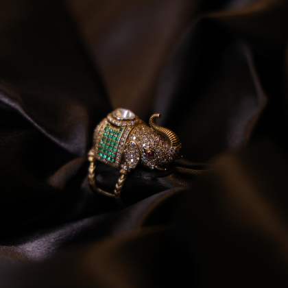 An exquisite elephant-shaped heritage ring adorned with uncut diamond, emeralds, and ruby detailing.