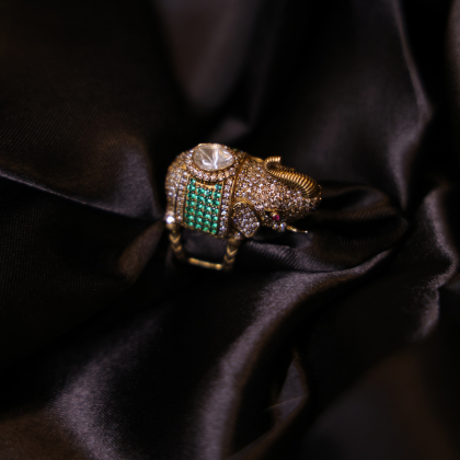 An exquisite elephant-shaped heritage ring adorned with uncut diamond, emeralds, and ruby detailing.